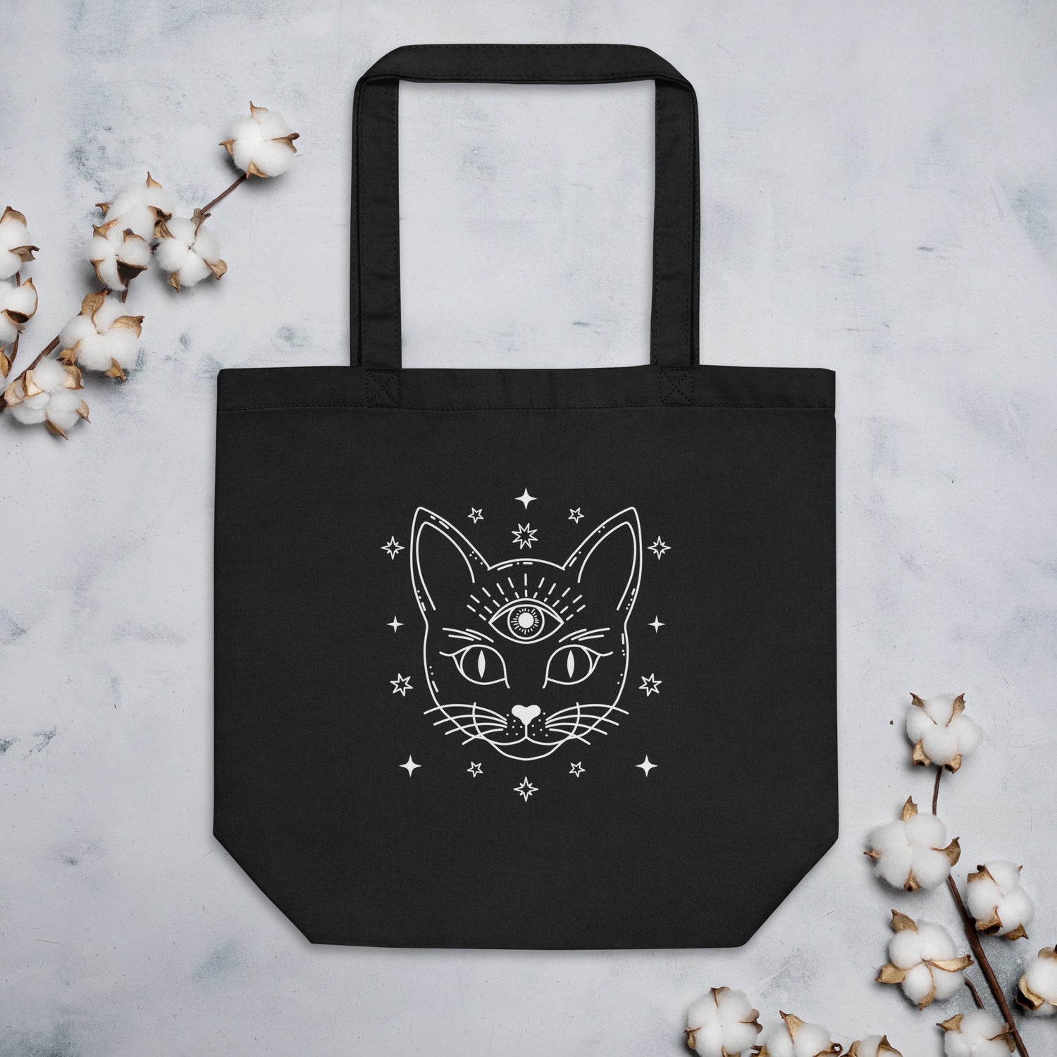 Black reusable tote bag featuring mystical cat print accessories design with stars and third eye