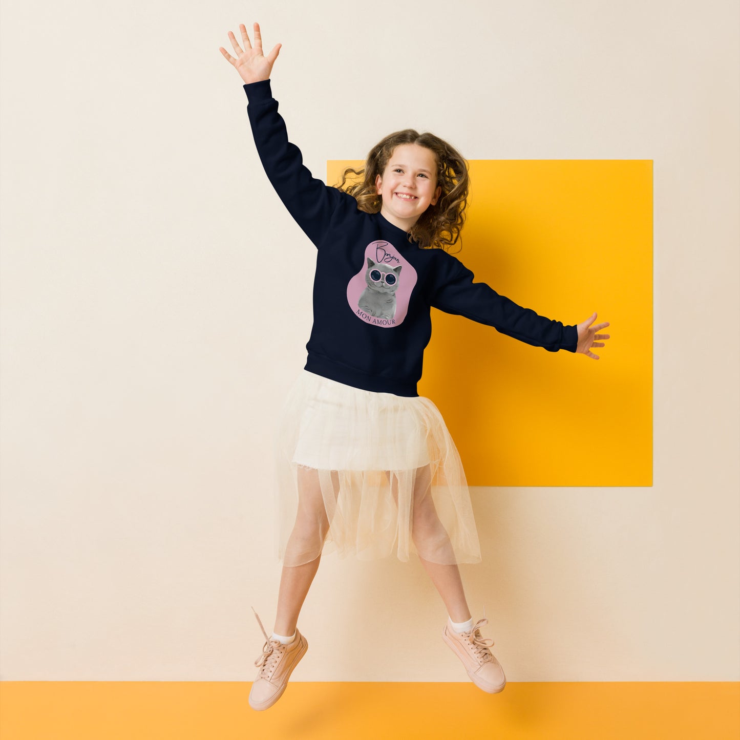 Child jumping wearing Pet Treasures Studio Bonjour Mon Amour crewneck for kids in navy with cat design