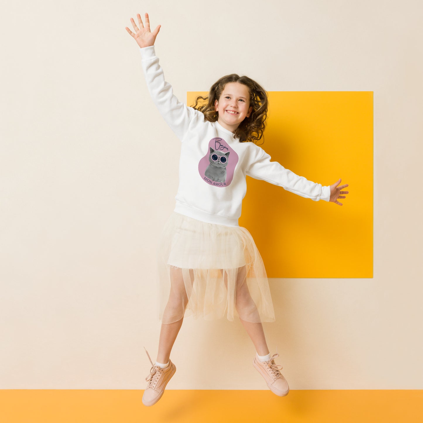 Smiling girl jumping wearing Pet Treasures Studio Bonjour Mon Amour crewneck for kids with owl graphic
