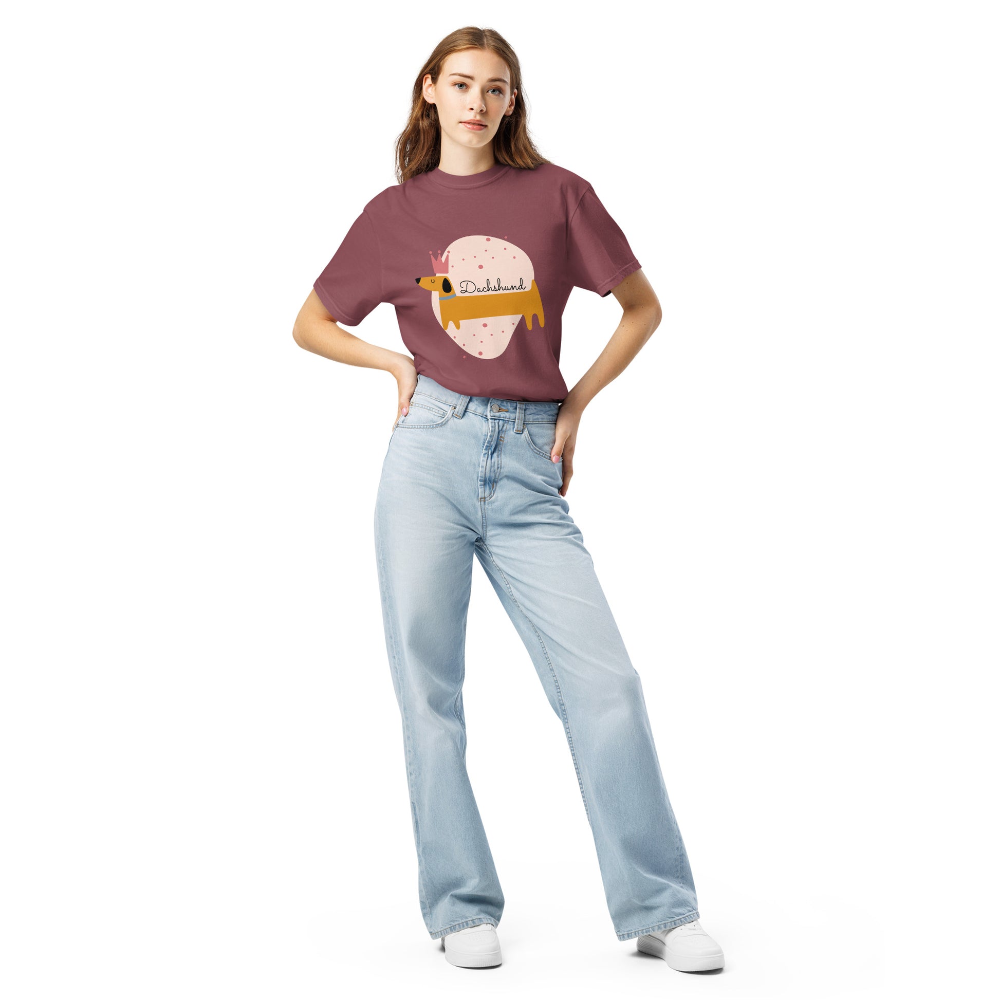 Woman wearing a mauve dachshund graphic t-shirt by Pet Treasures Studio paired with light blue jeans and white shoes