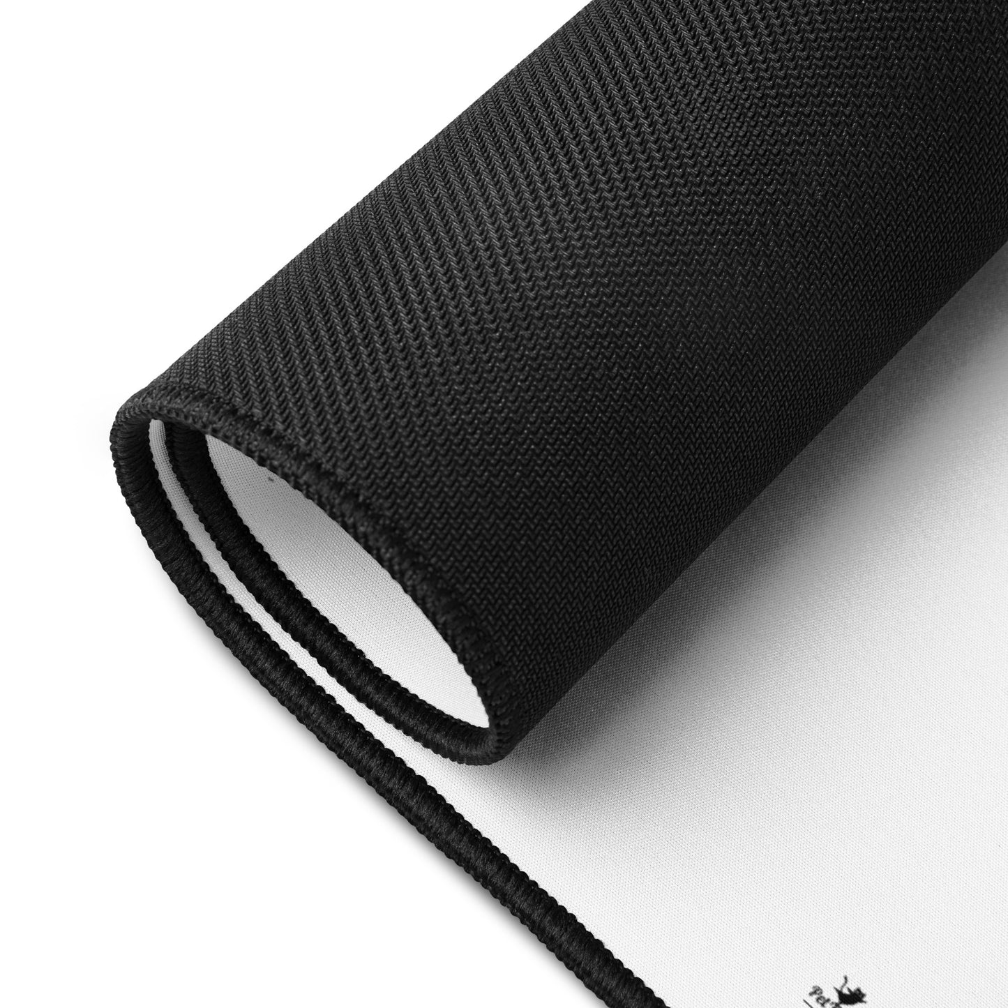 Black and white Yorkie desk pad rolled up showing textured edges and smooth surface